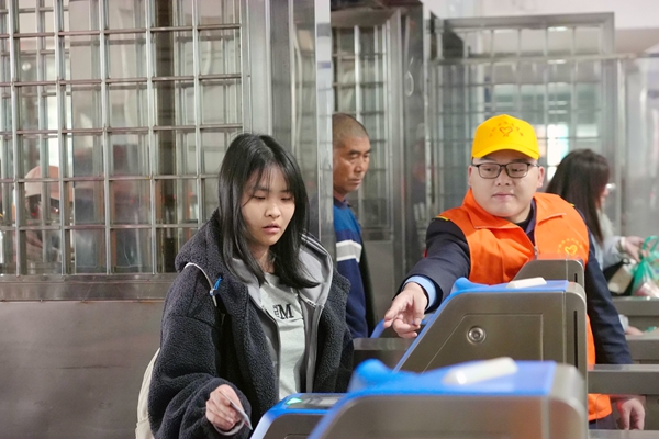青年志愿引导旅客快速通过闸机进站乘车。李超宇摄