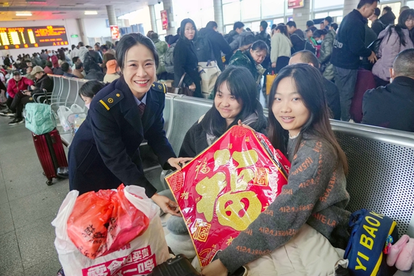 客运员为旅客送“福”。李超宇摄