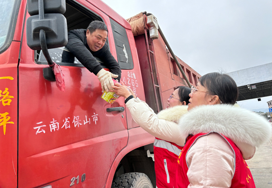 八步公路养护中心党员志愿者为司机发放物资。梁月摄