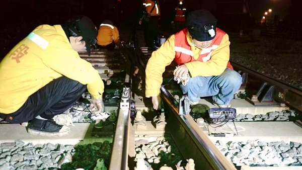 探伤工在玉林站场使用焊缝探伤仪对钢轨进行探伤作业，确保春运平安。谭育俊摄