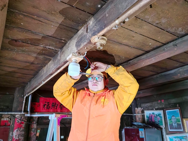 青年志愿者为村民修整线路。姚斌摄