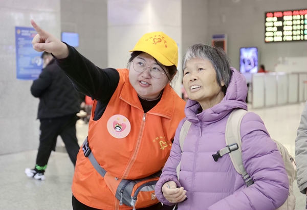 桂林火车站青年志愿者为旅客提供候乘引导服务。郑长贤摄