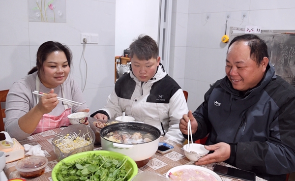 杨敏与家人围坐在一起，吃上了美味的火锅，其乐融融。