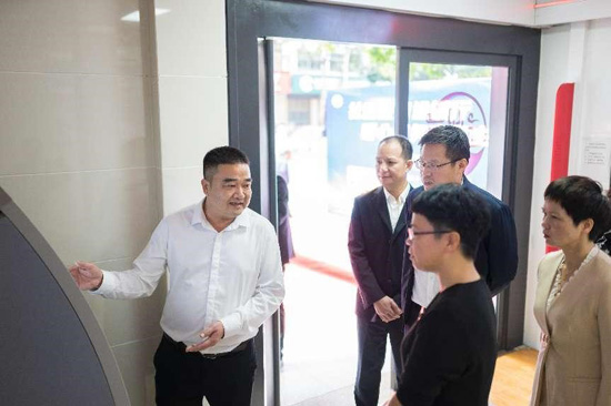 县社保中心主任谢臻指导使用社保服务自助一体机办理社保业务
