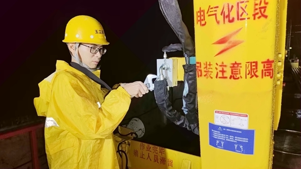 轨道车司机冒雨检查轨道车辆设备和走行部位，拧紧设备螺丝，做好出车运输准备工作。张业深摄