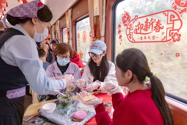 Z6次列车工作人员与旅客一起包饺子。黄舞杰摄