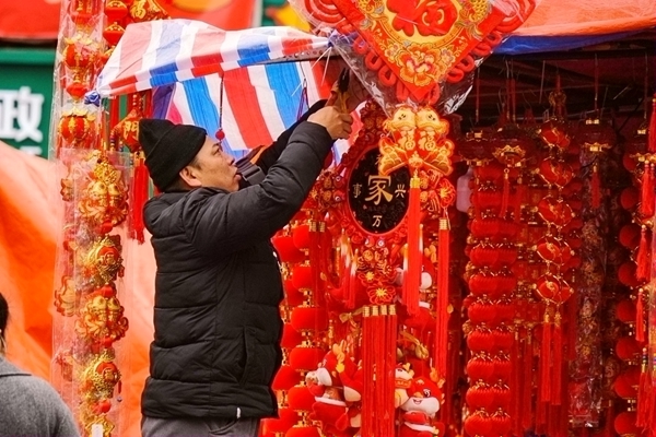 摊主在整理年味挂饰。黄小倩摄