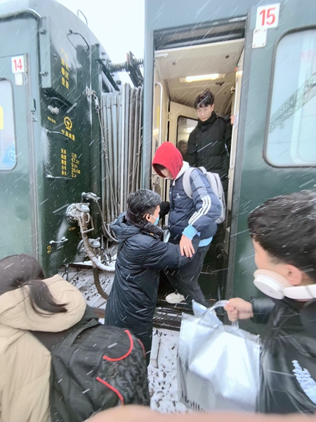 2024年2月4日，T289次列車因受強降雪影響晚點到達西平站，硬座車廂全體乘務員冒著大雪在車門口攙扶旅客下車。張楊久 攝.jpg