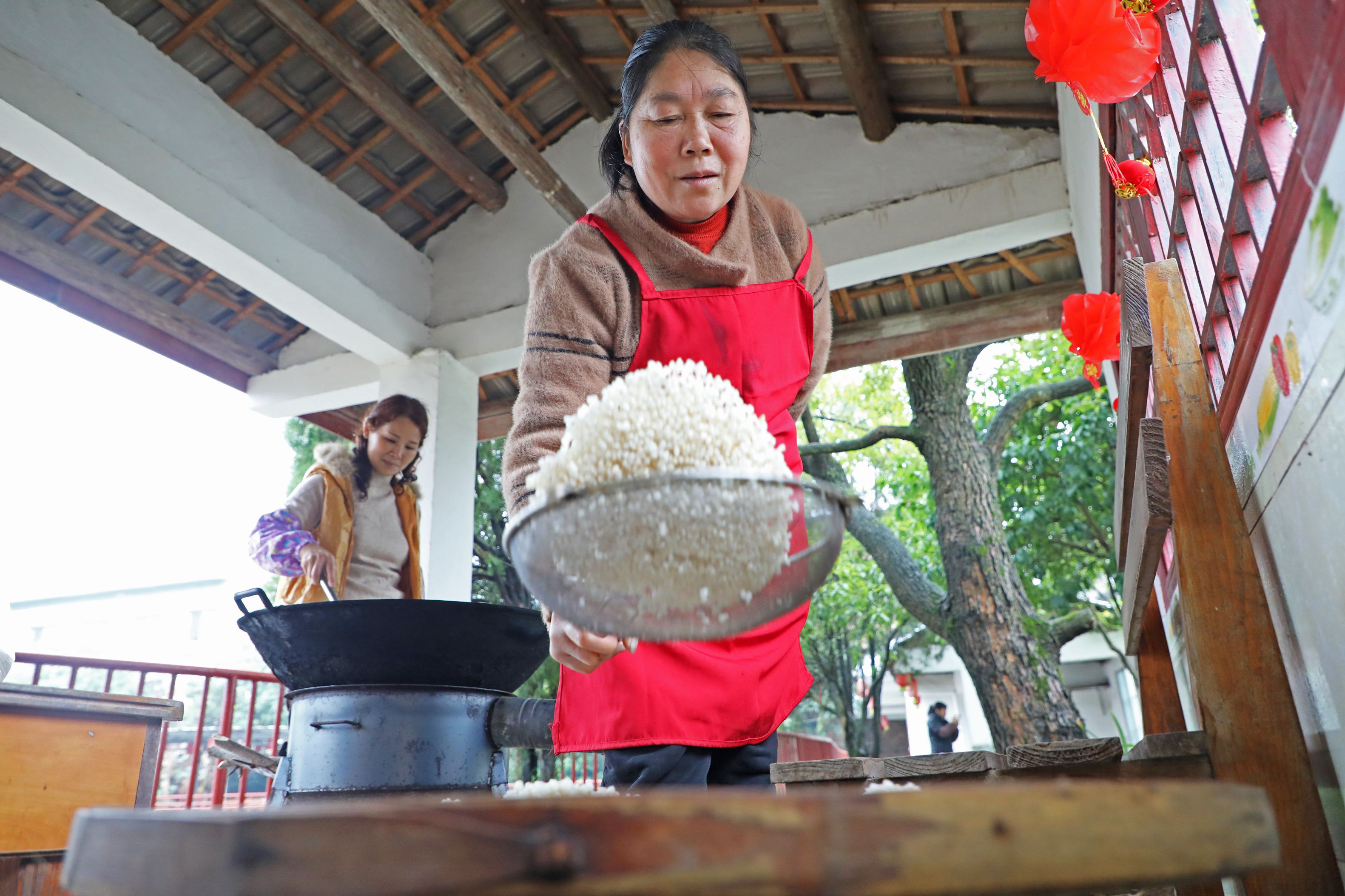 村民給炒制好的米花濾油。陽海翔攝