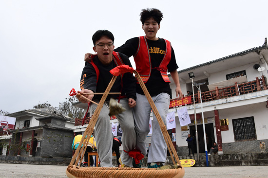 2月14日，游客在石围古村参加抢粽粑比赛。