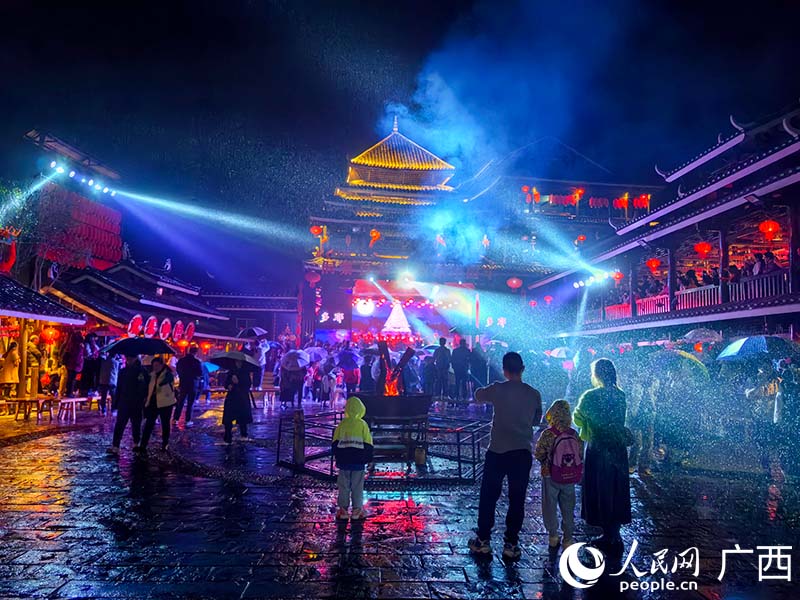 游客在三江程阳八寨景区参与民俗体验活动。人民网 付华周摄