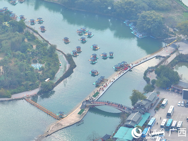 游客在阳朔遇龙河景区排队乘坐竹筏。人民网 付华周摄