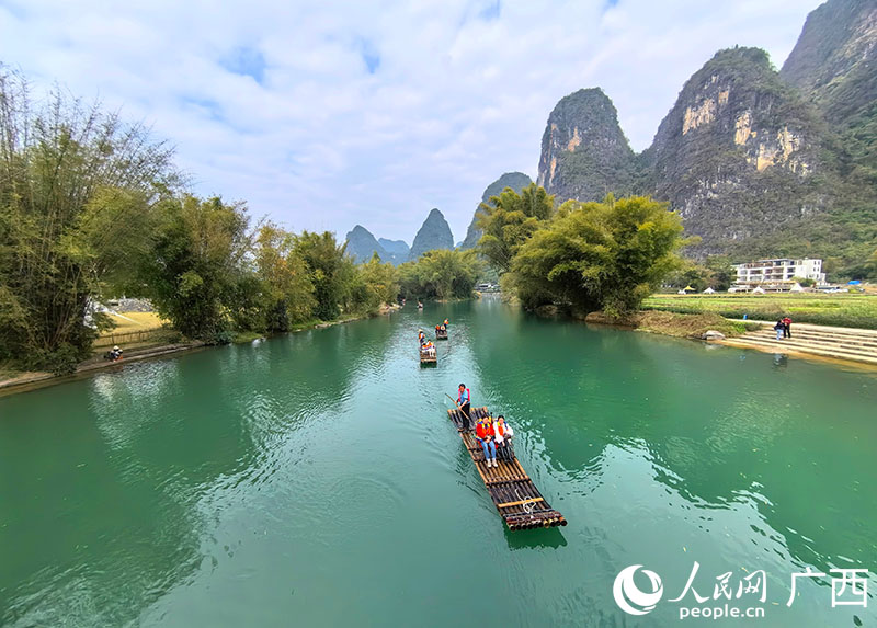 游客乘坐竹筏在遇龙河上观光。人民网 付华周摄