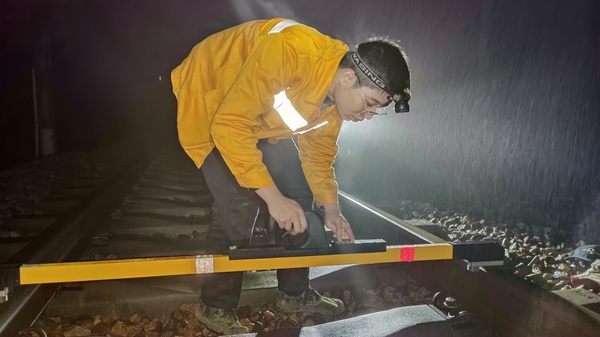 职工正在使用道尺检测线路高低、方向、水平等几何尺寸和线路钢轨平顺度。李慕传摄