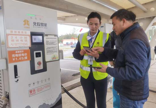 邓彩凤帮助旅客使用新能源汽车充电桩。陈小迎摄