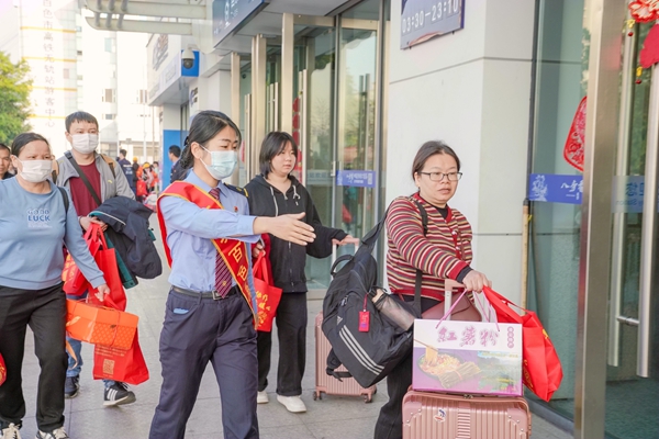 百色站“刘三姐·红城百色服务队”引导旅客有序进站。秦塬棋摄