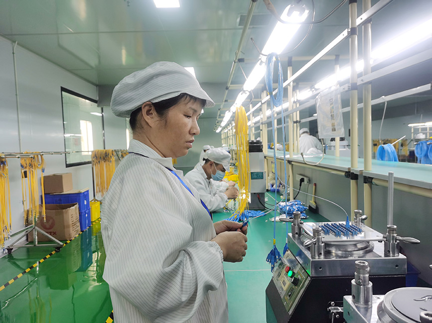 生產車間裡工人正有條不紊地進行設備操控、檢驗產品等作業。梁桂花攝