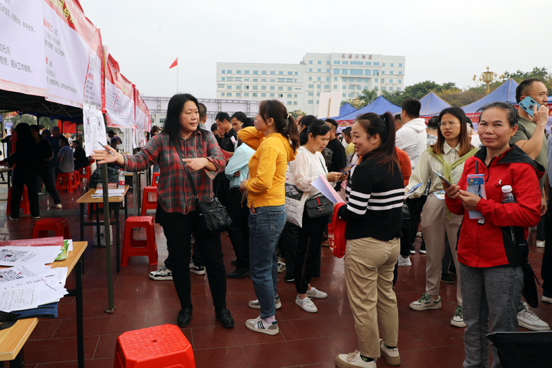 企业招聘人员在现场解答求职者问题。粟柳晴摄