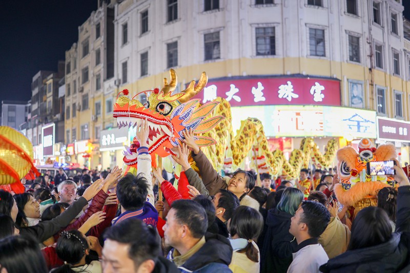 非遗表演进行时，市民摸龙祈福，通过“沾龙气”祈求在新的一年里平安幸福、吉祥如意。 陈起东摄