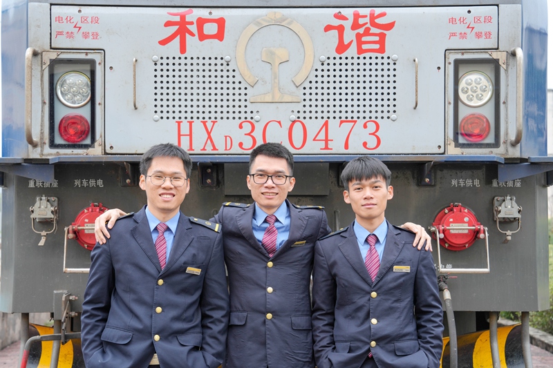 三兄弟在机车前一期合影，左起依次为：李映波、李坤龙、李金龙（劳福宁 摄）.jpg