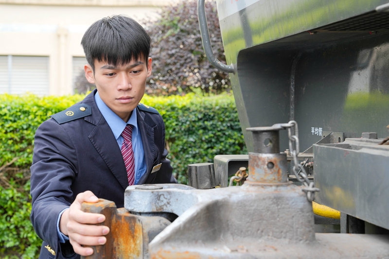李金龙正在检查机车车钩（劳福宁 摄）.jpg
