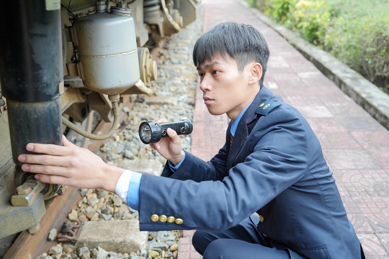 李金龙正在检查机车走行部（劳福宁 摄）.jpg