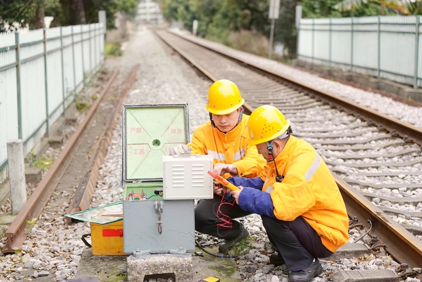 2月22日，柳州電務段職工正在桂林南貨場道口到達點對信號箱盒進行排查，避免雨水滲入影響設備安全。文毅攝