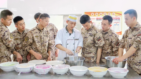 炊事员正在向官兵们传授包元宵的技巧