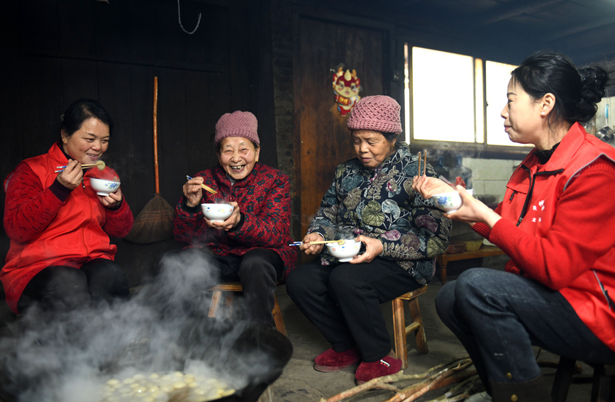 村民围坐在一起吃汤圆。潘志祥摄