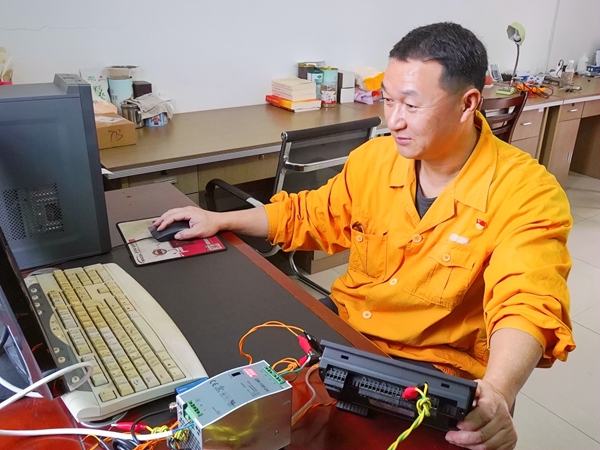 彭春林正在使用计算机调整设备逻辑参数。马君摄