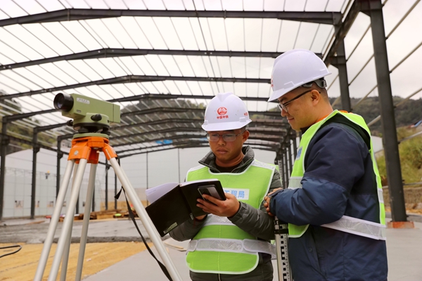 施工人员在对临建工程场地进行测量。莫小斌摄