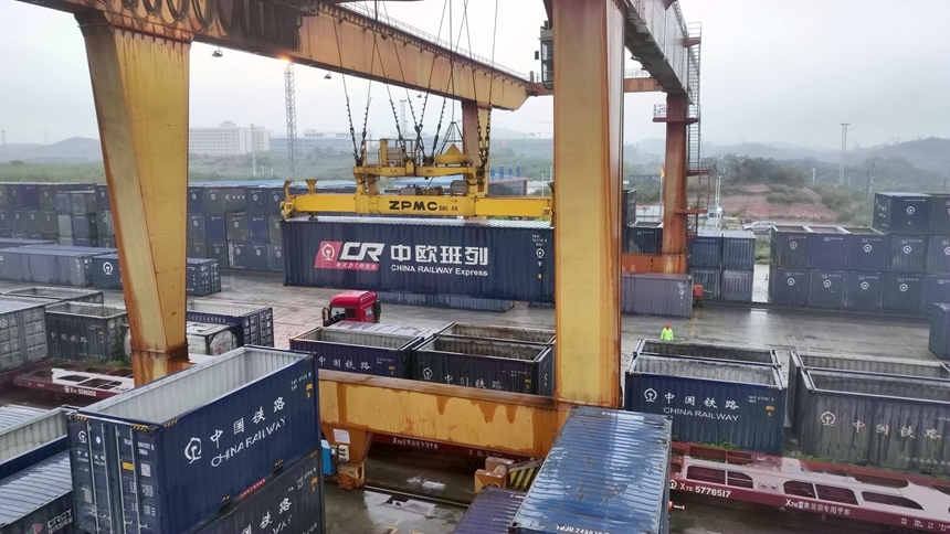 南宁国际铁路港跨境货物集装箱正在从汽车卸下吊装上火车。邢星摄