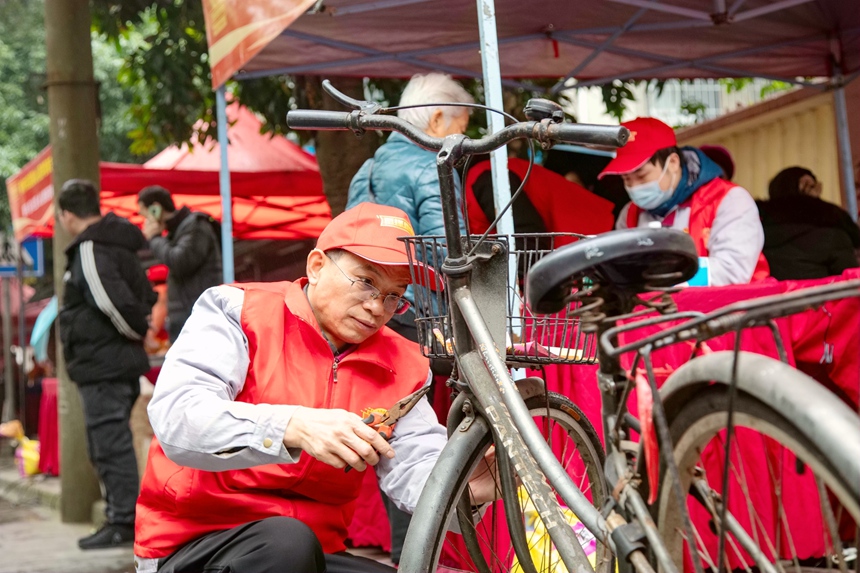 圖為志願者為市民維修自行車。蔣少闐攝