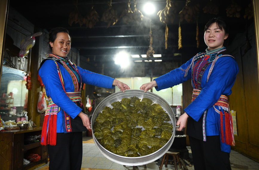 瑶族妇女在展示刚蒸熟出炉的艾粑。潘志祥摄