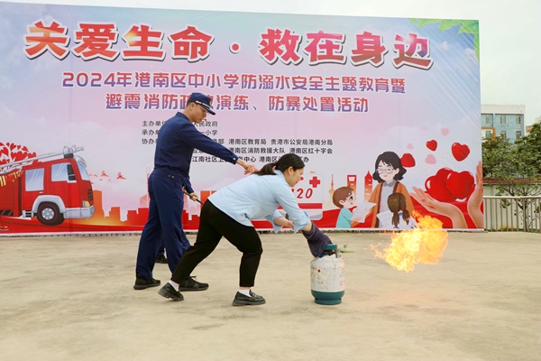消防隊員指導老師關閉著火的煤氣罐。
