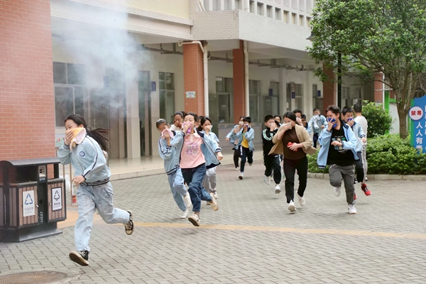 學生在模擬火場濃煙環境下演練疏散逃生。