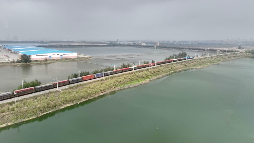 一列满载货物的西部陆海新通道铁海联运班列从钦州港东站驶出。陈磊摄