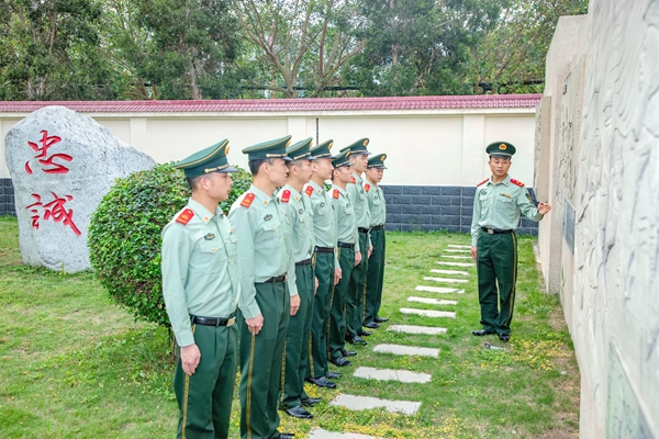 在缅怀先烈场所前，红色宣讲员为官兵讲述战役故事。