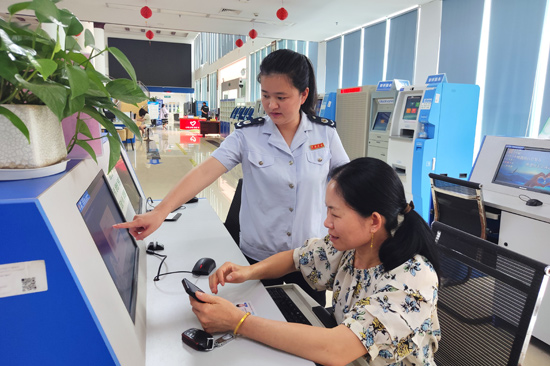 4月3日,东兴市办税服务厅内,税务局工作人员协助群众办理业务。方平摄