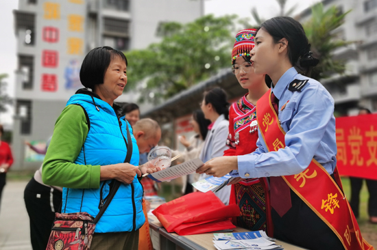 防城区税务局干部用“双语”为那里蒙社区居民宣传税费知识。黄家丽摄