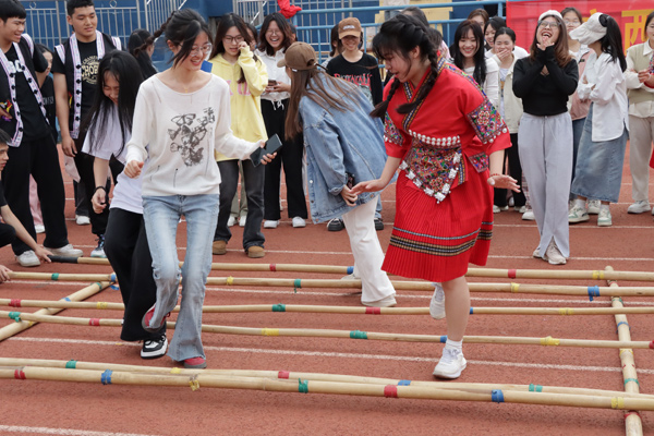 学生在体验跳竹竿舞。冯卓摄