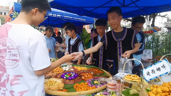 活动中，学生在售卖特色美食。右江区委宣传部供图