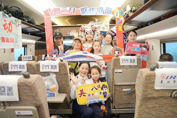 G422次列车上，列车乘务员和旅客合影。曹烁摄
