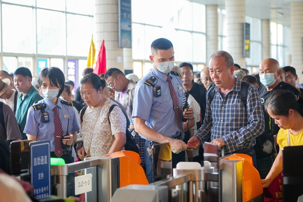 湛江站客运员有序引导旅客安全过闸机进站乘车。李超宇摄