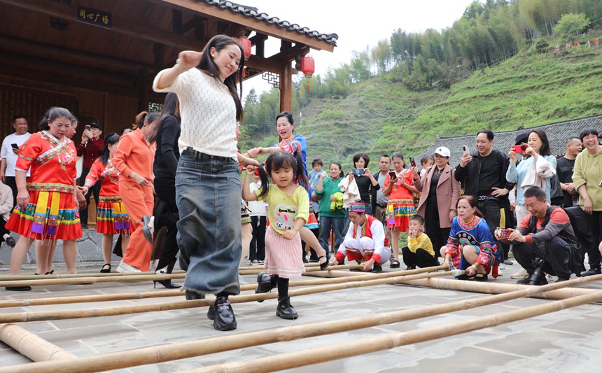 在资源县车田苗族乡石山底屯，群众在跳竹竿舞。