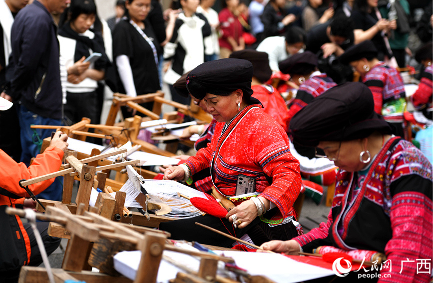 瑤族婦女在向中外游客展示瑤族服飾制作工藝。潘志祥攝
