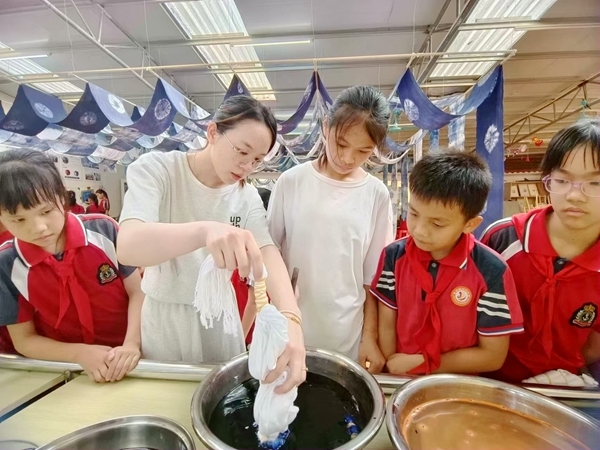 黃練鎮中心小學教師向學生講解示范扎染技巧。