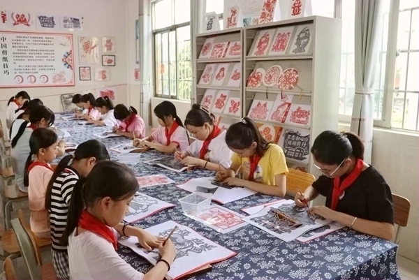 蒙公镇中心小学学生在学习剪纸。