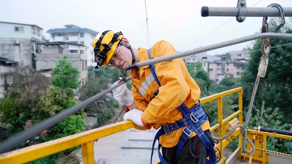青年职工对接触网设备画标示线。蔡星宏摄