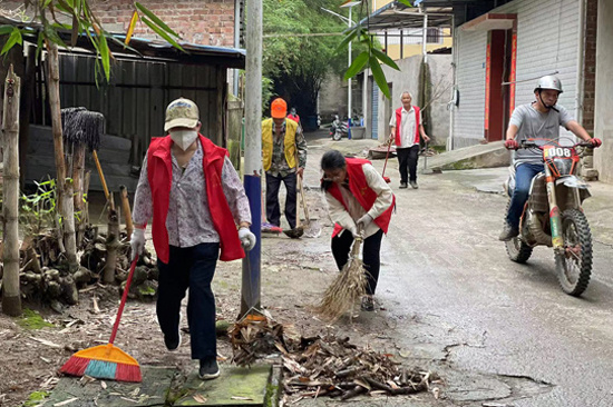 村民、志愿者清理村道两旁垃圾。莫彦彬摄